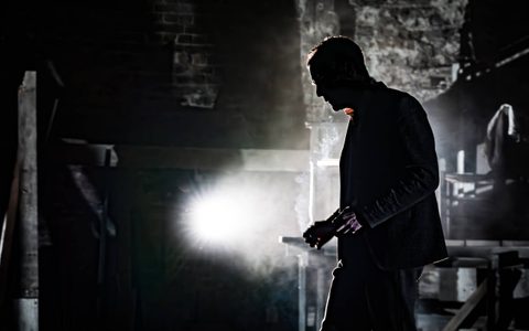 The silhouette of Michael Shannon in side profile, with a bright white spotlight in the background.