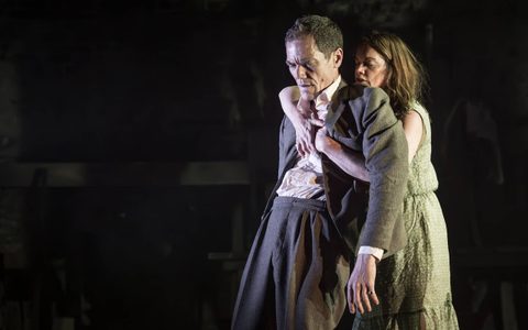 Michael Shannon wears a grey suit and leans back against Ruth Wilson, who wraps her arms around him from behind. She wears a green dress and has her eyes closed.