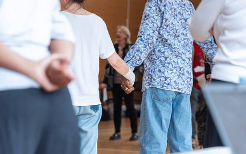 People holds hands in a rehearsal room.
