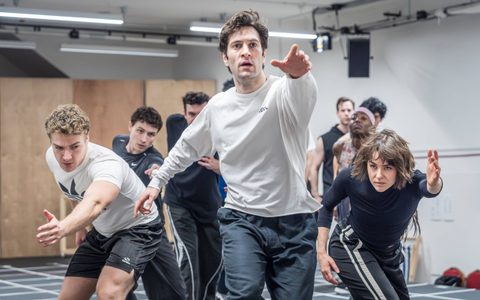 The American Psycho company rehearsing choreography. Art Froushan is at the front, with one arm raised.