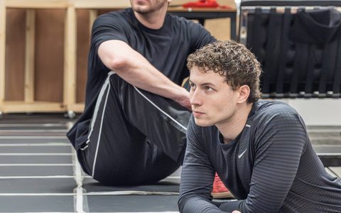 Jack Butterworth and Alex James-Hatton lean on a marked platform in a rehearsal room.