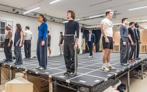 The American Psycho company rehearsing on a marked platform.
