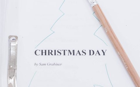 Christmas Day script with a Christmas tree drawn on the cover. A pencil lies at an angle on top of it.