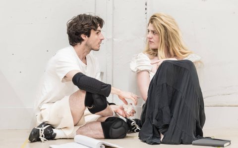 Luke Cinque-White and Lizzy Connolly sit on the floor surrounded by scripts.