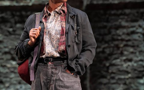 Francesca Amewudah-Rivers wears black jeans and layered shirts. She looks off the side, holding a bag on her shoulder.