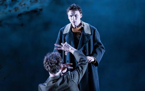 Stuart Thompson wears a large dark coat and looks at Kyle Soller, who has his back to the camera and looks towards him. Stuart has a worried expression.