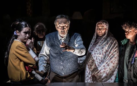 Bijan Daneshmand, Mona Goodwin, Esma Akar and Adi Gimziunas stand in a dark room. Bijan is reaching forward and the rest are looking apprehensively towards him.