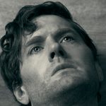 A close crop of Kyle Soller's face in black and white.