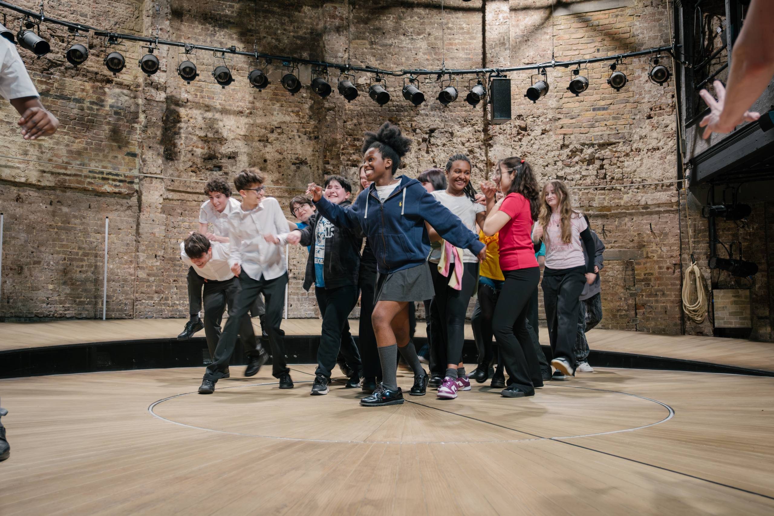 Students dancing together on the Almeida Theatre stage.