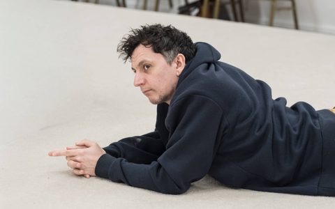 Tom Mothersdale lays on his belly with his hands clasped together.