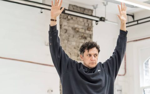 Tom Mothersdale stands with both arms in the air.