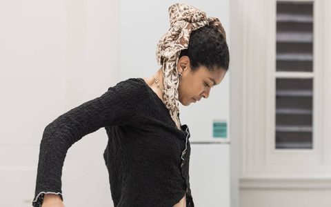 Thalissa Teixeira has her head bent down with her right arm slightly bent looking at the floor.