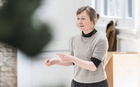 Collaborating Director Jenny Ogilvie stands gesturing with her hands as if explaining something.